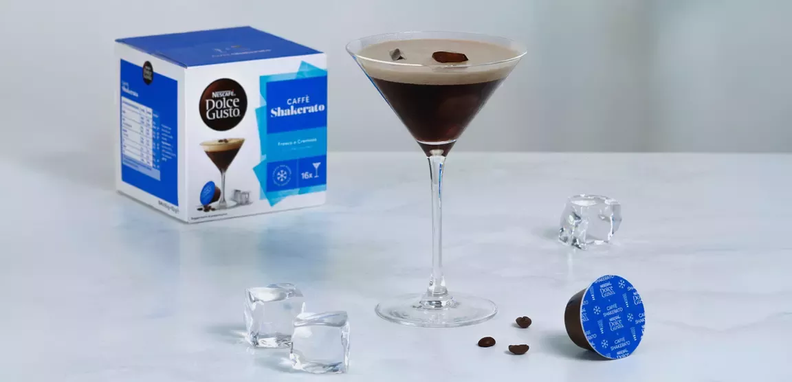 Caffè Shakerato Nescafé Dolce Gusto servito con ghiaccio e capsule su sfondo chiaro