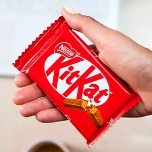 Confezione di KitKat tenuta in mano con wafer al cioccolato in evidenza